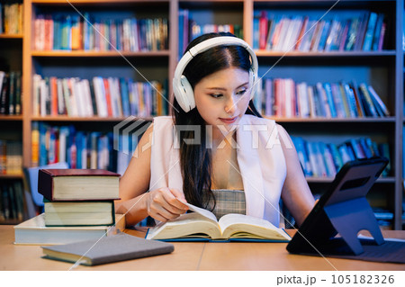 Young woman reading books and working in library for education Young woman reading books and working in library for education 105182326