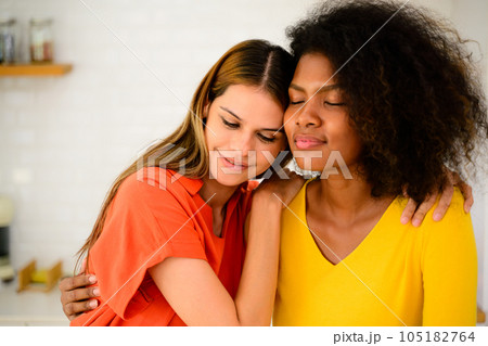 Happy young lesbian couple embracing together, Couple of friends relaxing and spending time on weekend at home, Couple of female lovers with good relationship, Concept of LGBTQ 105182764