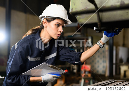Confident female technician engineer worker checking and inspecting machine Confident female technician engineer worker checking and inspecting machine 105182802