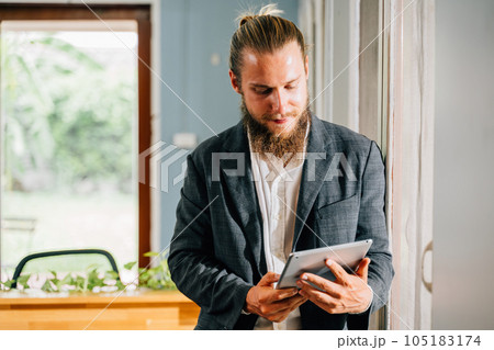 Portrait of smart businessman holding tablet working at modern office Portrait of smart businessman holding tablet working at modern office 105183174