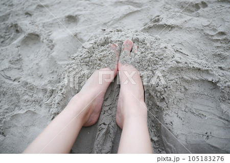 Feet of Young woman having fun at beach. Feet on sand at the beach. 105183276