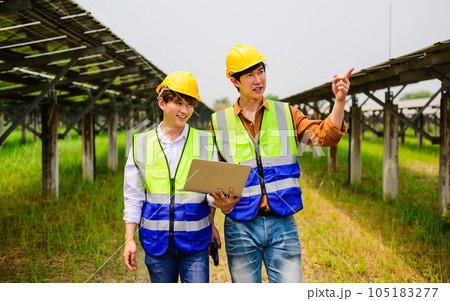 Maintenance engineer checking solar panels on solar cell farm 105183277