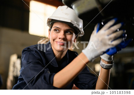 Confident female technician engineer worker checking and inspecting machine Confident female technician engineer worker checking and inspecting machine 105183398
