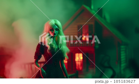 creepy doll at night against the backdrop of a scary house 105183627