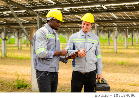 Maintenance engineers team checking solar panels on solar cell farm 105184096