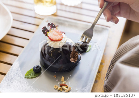 デザートプレートのチョコレートケーキを食べる女性手元 105185137