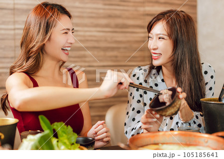 Happy woman dining in hotpots restaurant Happy woman dining in hotpots restaurant 105185641