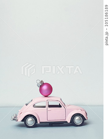 Miniature automobile with a Christmas decoration on a blue background Miniature automobile with a Christmas decoration on a blue background 105186189