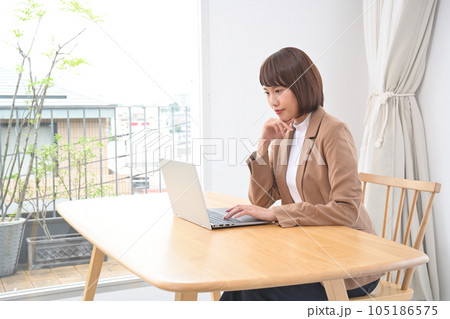 屋内の机でディスクワークをする若い女性 屋内の机でディスクワークをする若い女性 105186575