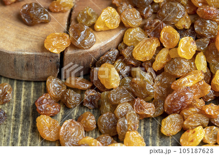 Dried yellow golden raisins on a board 105187628