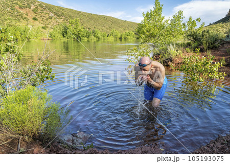 senior male swimmer is splashing himself at lake shore - Horsetooth Reservoir new Fort Collins in summer scenery senior male swimmer is splashing himself at lake shore - Horsetooth Reservoir new Fort Collins in summer scenery 105193075