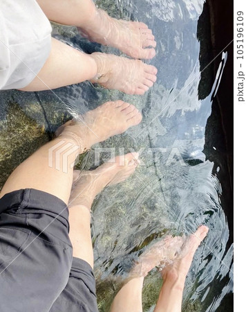 足湯に浸かる3人の女性の足元 105196109