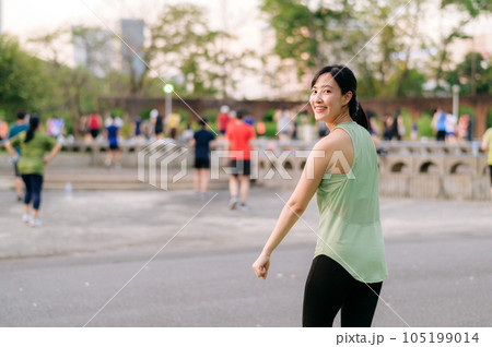 Female jogger. Fit young Asian woman with green sportswear aerobics dance exercise in park and enjoying a healthy outdoor. Fitness runner girl in public park. Wellness being concept Female jogger. Fit young Asian woman with green sportswear aerobics dance exercise in park and enjoying a healthy outdoor. Fitness runner girl in public park. Wellness being concept 105199014