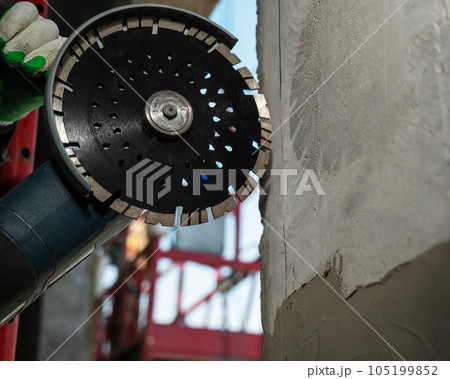 Master cuts a concrete wall with a circular diamond saw. Master cuts a concrete wall with a circular diamond saw. 105199852