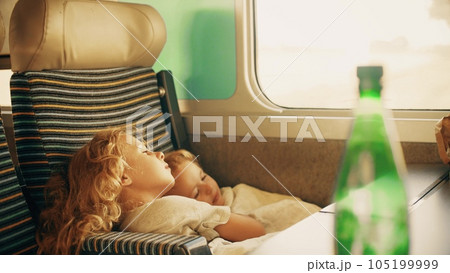 Two little sisters trying to get some sleep in the single high speed train seat 105199999