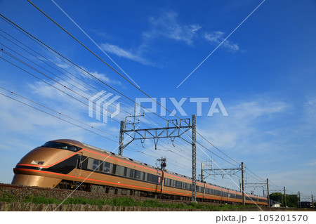 水鏡の田んぼと東武日光線を行く日光詣カラーの特急電車 105201570