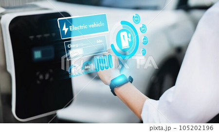 Businessman check EV car battery status on smartwatch hologram. Peruse 105202196