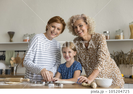 Happy kid, beautiful mom and grandma having fun and baking Happy kid, beautiful mom and grandma having fun and baking 105204725