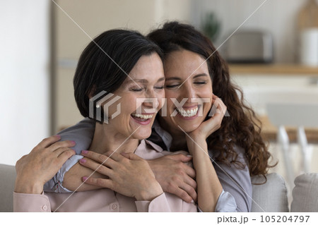 Happy positive mature mother and adult kid woman hugging, cuddling Happy positive mature mother and adult kid woman hugging, cuddling 105204797