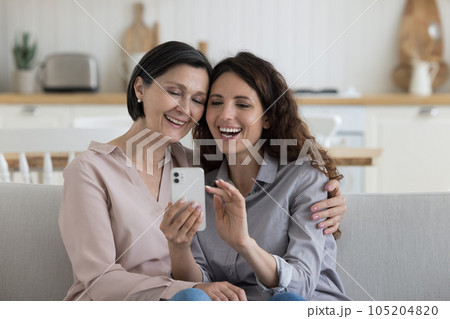 Positive happy adult child woman taking selfie on smartphone 105204820
