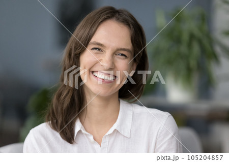 Closeup cheerful woman laughing seated on sofa staring at camera 105204857