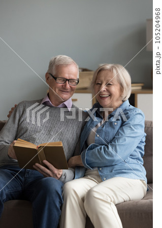 Retired husband and wife spend time reading book at home Retired husband and wife spend time reading book at home 105204968