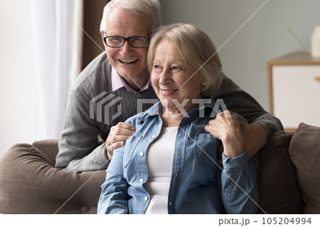 Peaceful mature couple daydreaming together at home Peaceful mature couple daydreaming together at home 105204994