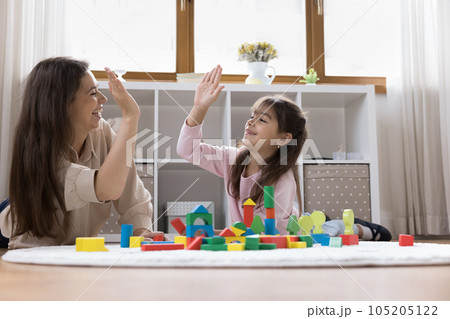 Happy mom and sweet preschool child girl giving high five 105205122