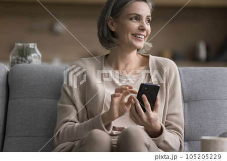 Happy pretty middle aged woman holding mobile phone, using application Happy pretty middle aged woman holding mobile phone, using application 105205229
