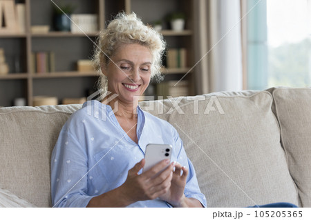 Happy senior mature woman using online application at home Happy senior mature woman using online application at home 105205365