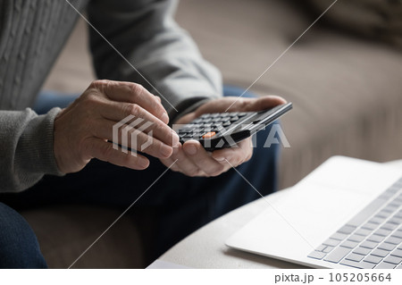 Senior man using calculator calculates expenses and incomes Senior man using calculator calculates expenses and incomes 105205664
