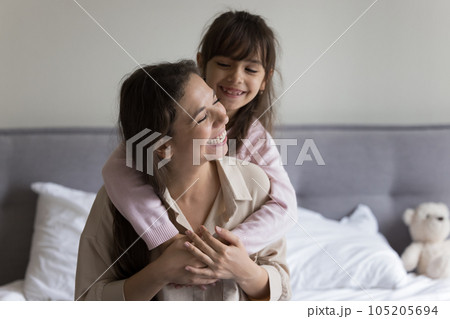 Excited joyful mom and kid girl playing and hugging 105205694