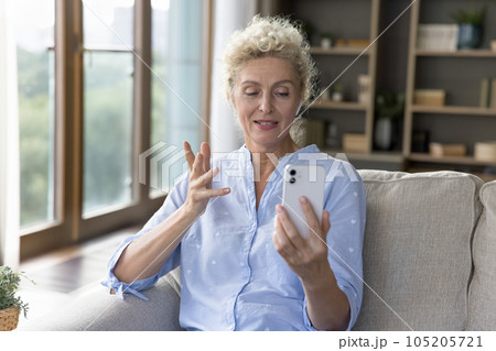 Positive beautiful blonde mature woman speaking on video call 105205721