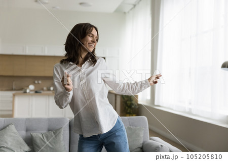 Untroubled woman dancing in cozy studio apartment Untroubled woman dancing in cozy studio apartment 105205810