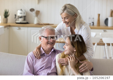 Cheerful grandma and grandpa hugging teenage kid Cheerful grandma and grandpa hugging teenage kid 105206197
