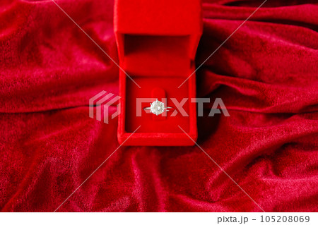 Diamond ring in jewelry gift box on red fabric background 105208069