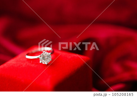Diamond ring with jewelry gift box on red fabric background Diamond ring with jewelry gift box on red fabric background 105208165