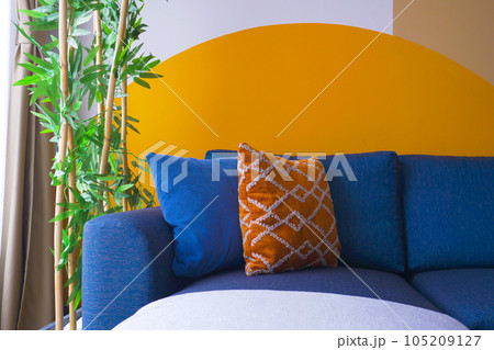 modern blue color sofa with pillows in living room against orange color wall  105209127