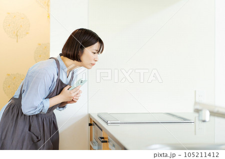 IHコンロを操作する女性 IHコンロを操作する女性 105211412