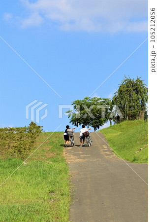 鳩山町愛郷の里の丘に向かう坂道を自転車を引いて登る二人の少年 105212056