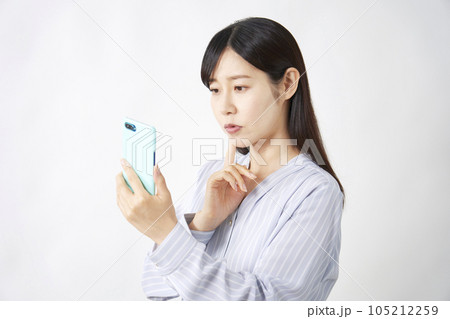 スマートフォンを持って考えるミドルエイジの女性 105212259