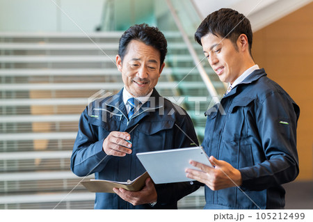 オフィスで打合せをする作業員の男性 オフィスで打合せをする作業員の男性 105212499