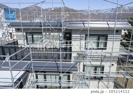 住宅リフォーム 外壁塗装と屋根の張替え作業中の家（空撮） 105214152