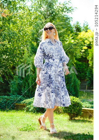 Happy woman in patterned dress on the lawn 105214294