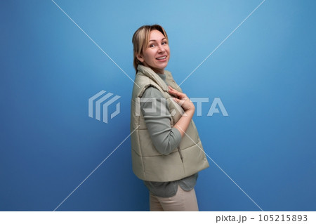 charming blond european lady in spring clothes on a blue background with copy space 105215893