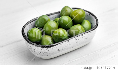 Plate with green olives on white background Plate with green olives on white background 105217214