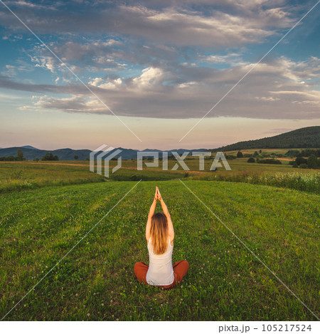 Woman doing yoga on the green grass at the mountain. Carpathians 105217524