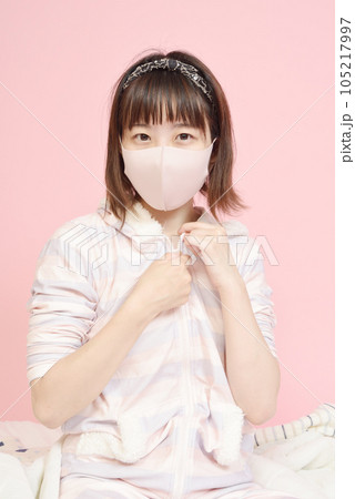 パジャマのファスナーを下ろす若い女性 105217997