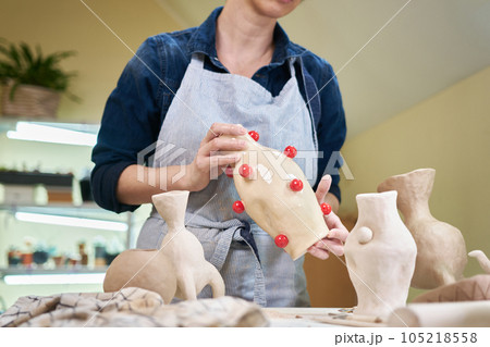 woman sculptor holding ceramic vase in artistic studio woman sculptor holding ceramic vase in artistic studio 105218558
