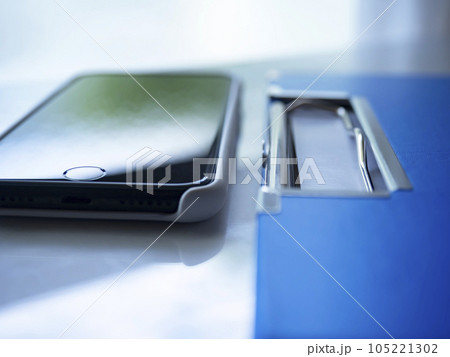 テーブルに置かれたバインダーとスマートフォン テーブルに置かれたバインダーとスマートフォン 105221302